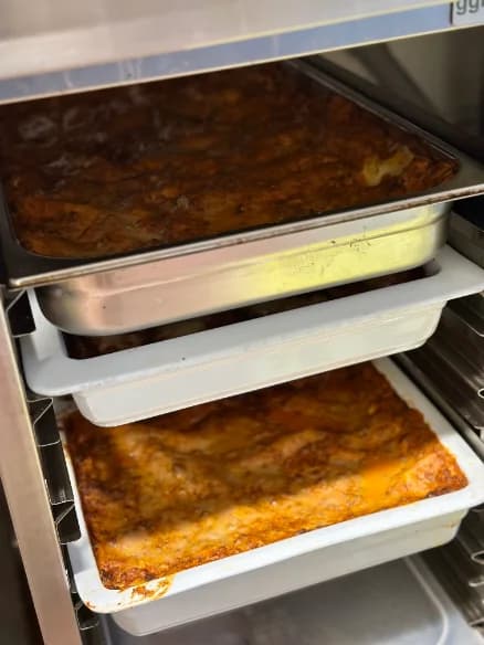 Trays of baked dishes on a kitchen rack