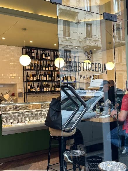 The deli storefront with the counter and wine shelves