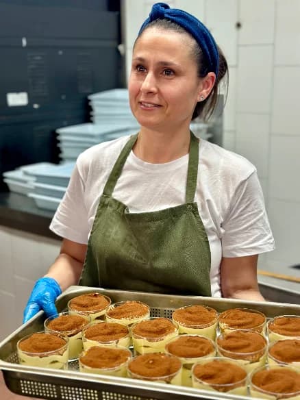 A cook carrying a tray of ready dishes